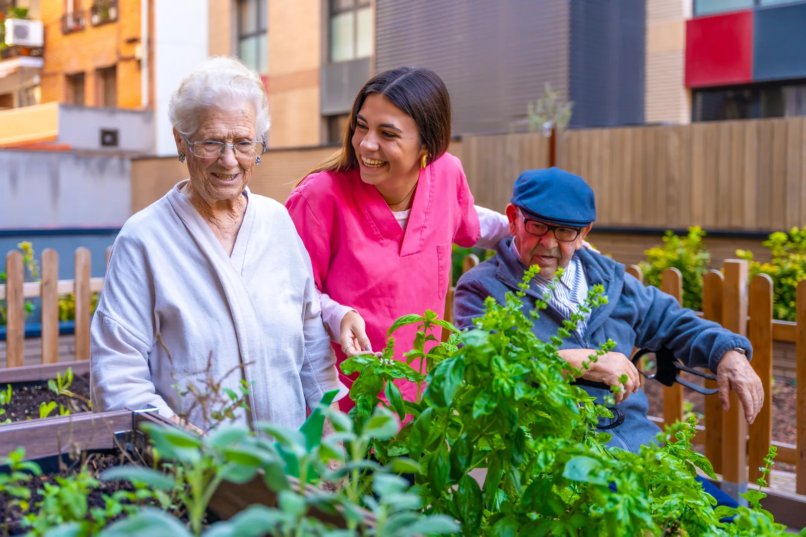 Verpleegkundige met bewoners in de tuin