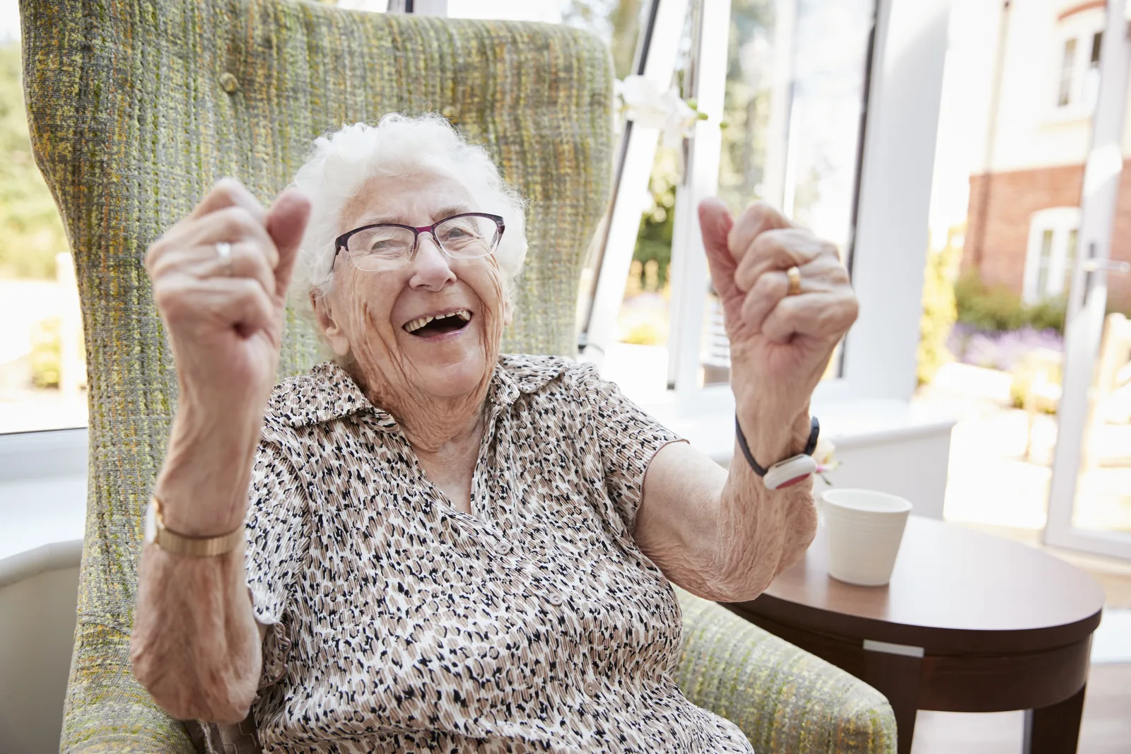 Blije oudere vrouw in haar stoel