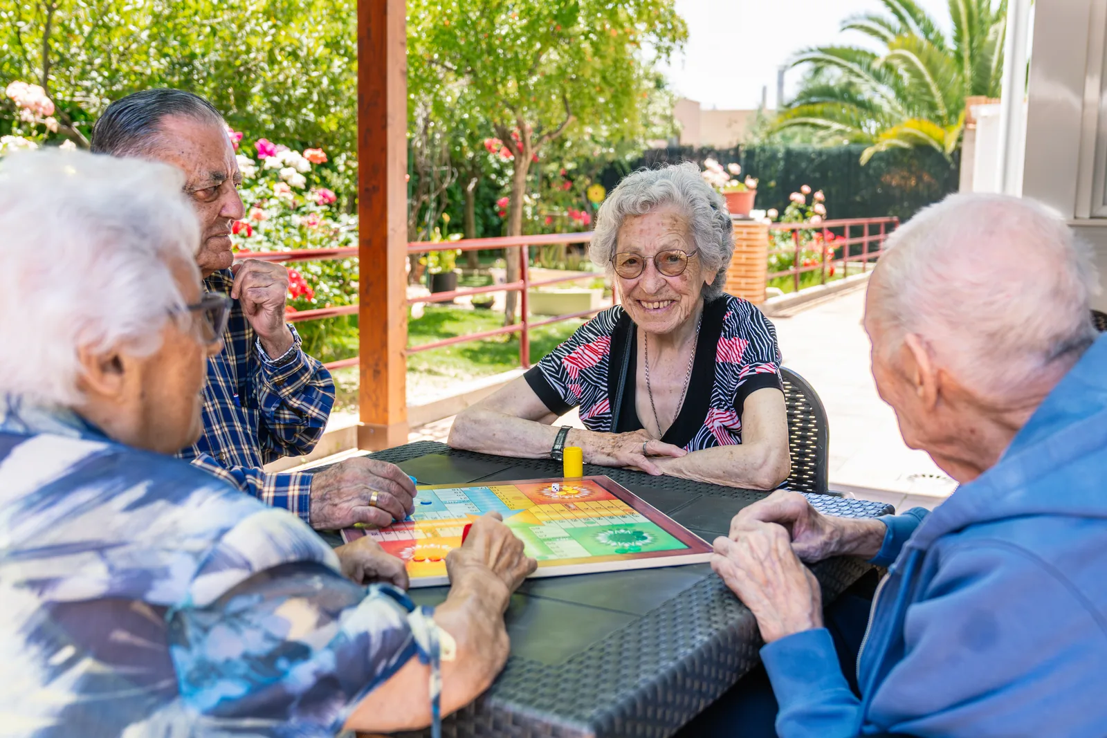 Ouderen spelen een bordspel in de tuin
